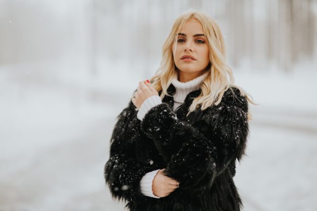 Blonde woman outside in snow winter coat